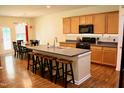 Spacious kitchen featuring a central island with seating, wood cabinets, and modern appliances at 642 Collington Dr, Mebane, NC 27302