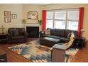 Cozy living room with a fireplace, plush leather seating, and a colorful decorative rug at 642 Collington Dr, Mebane, NC 27302