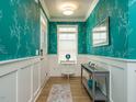 Stylish entryway with teal leaf-patterned wallpaper, white wainscoting, and a modern console table at 67 Blue Spruce Cir, Clayton, NC 27527