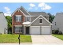 Attractive two-story home with a brick and siding exterior, complemented by a well-maintained front lawn and two-car garage at 7414 Brandon Allen Ave, Raleigh, NC 27613