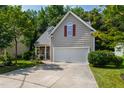 Charming home featuring a two-car garage, stone porch accents, and well-maintained landscaping at 8205 Rolling Glenn Dr, Raleigh, NC 27616