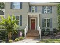 Close up of a charming home featuring a brick stairway leading to a bright red front door and blue shutters at 860 Cokesbury Rd, Fuquay Varina, NC 27526