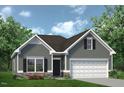 Charming single-story home featuring a two-car garage, stone accents, and well-manicured landscaping at 104 E American Marigold Dr # 59, Benson, NC 27504