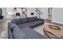 Inviting living room with plush sectional sofa, stylish coffee table, and staircase in a modern, neutral color palette at 128 Chapel Run Way, Chapel Hill, NC 27517