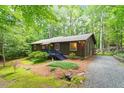 Exterior view of house surrounded by green trees with a gravel driveway and lush landscaping at 1403 Meadow Ln, Chapel Hill, NC 27516