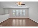 Well-lit living area with hardwood floors, large windows, and neutral walls at 1434 Salem Dr, Apex, NC 27502