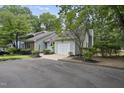 Charming exterior featuring a garage and lush landscaping, enhancing the curb appeal at 1500 Laureldale Dr, Raleigh, NC 27609