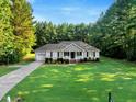 Charming single-story home features a well-manicured lawn and tidy landscaping, complemented by a long driveway at 1515 Bradsher Dr, Stem, NC 27581