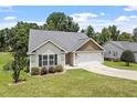 Attractive one-story home with a two-car garage, manicured lawn, and mature trees adding to its curb appeal at 21 Cambridge Dr, Angier, NC 27501