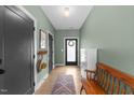 Inviting entryway featuring neutral paint, wood floors, storage cabinet and wood bench with a front door wreath at 2201 Millbank Village Ct # 101, Raleigh, NC 27610