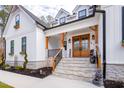 Inviting front porch with stone steps, wood columns, and a striking double-door entrance at 257 Rawhide Dr, Louisburg, NC 27549