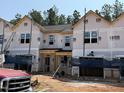 New construction townhomes showcase modern design with covered entries and durable siding, still in the building phase at 27 Calluna Dr, Clayton, NC 27520