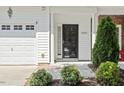 Up close view of a front door with tidy bushes and an attached single car garage at 3021 Winding Waters Way, Raleigh, NC 27614