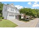 Street view of a two-story townhouse showcasing a landscaped front yard, sidewalk, and attached garage at 3021 Winding Waters Way, Raleigh, NC 27614