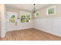 Classic dining area with wainscoting, LVP floors, a modern light fixture, and a door to the backyard at 303 Godwin St, Selma, NC 27576