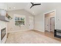 Bright living room with vaulted ceiling, neutral paint, luxury vinyl plank flooring and fireplace with mantle at 303 Godwin St, Selma, NC 27576