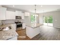 Bright, open kitchen with an island, stainless steel appliances, and a view of the backyard at 348 Danube Dr, Zebulon, NC 27597