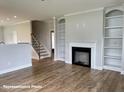 Spacious living room with a fireplace, built-in bookshelves, and hardwood floors at 348 Danube Dr, Zebulon, NC 27597