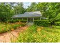 Inviting home with a welcoming porch, surrounded by beautiful landscaping and mature trees at 3506 Arthur Minnis Rd, Hillsborough, NC 27278