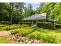 Inviting home with a welcoming porch, surrounded by beautiful landscaping and mature trees at 3506 Arthur Minnis Rd, Hillsborough, NC 27278