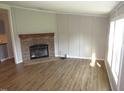 Inviting living room featuring a stone fireplace, wood-look floors, and natural light from the nearby windows at 440 Montgomery Rd, Franklinton, NC 27525