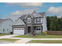 Beautiful home with stone accents, a two-car garage, and manicured lawn at 4416 Walker Hallow St, Raleigh, NC 27616