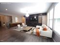 Staged living room with gray floors, white sofa and built-in entertainment center at 4416 Walker Hallow St, Raleigh, NC 27616