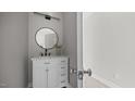 Bathroom featuring a white vanity, marble countertop, a round mirror, and modern lighting at 505 Hawfields Rd, Mebane, NC 27302