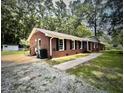 One-story brick home with a driveway, walkway, and lots of trees in the background at 512 Crestview Dr, Durham, NC 27712