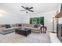 Cozy living room with a large sectional sofa, ceiling fan, and a view of the outdoors at 5900 Holly Dr, Raleigh, NC 27616