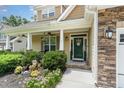 Inviting front porch with decorative landscaping and a charming entrance with decorative wreath at 6 Tulip Tree Ct, Durham, NC 27712