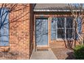 Close-up of a brick townhome's entrance with a painted door and blue shutters at 61 Fashion Pl, Durham, NC 27705