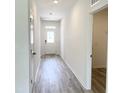 Hallway with grey wood-look flooring, white walls and white doors and trim at 67 Furley St., Homesite 117, Sanford, NC 27330