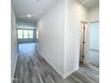 Hallway with grey wood-look flooring, white walls leads to living area at 67 Furley St., Homesite 117, Sanford, NC 27330