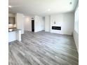 Open-concept living room featuring a fireplace and grey wood-look flooring at 67 Furley St., Homesite 117, Sanford, NC 27330
