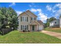 Charming two-story home with a well-manicured lawn, attached garage, and inviting curb appeal at 71 Herndon Ct, Clayton, NC 27520