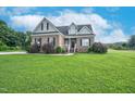 Inviting brick home featuring a manicured lawn and tasteful landscaping at 7107 Elkhorn Rd, Rocky Mount, NC 27803