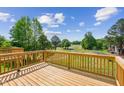 Beautiful wooden back deck overlooking the golf course with green trees and light blue sky at 749 Parc Townes Dr # 33, Wendell, NC 27591