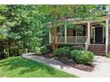 View of the landscaped front yard with a stone walkway leading to a covered front porch with decorative plants at 776 Legend Oaks Dr, Chapel Hill, NC 27517