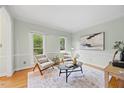 Bright living room with hardwood floors, decorative molding, and a large rug creating a cozy and elegant atmosphere at 7808 Sandy Bottom Way, Raleigh, NC 27613
