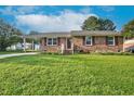 Charming brick home featuring a well-manicured lawn and a convenient carport at 801 Lincoln Dr, Rocky Mount, NC 27801