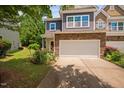 Attractive townhouse featuring a stone facade, two-car garage, and garden at 809 Davidson Point Rd, Cary, NC 27513