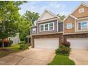 Townhouse featuring gray siding, a stone base, and a well-maintained front yard at 809 Davidson Point Rd, Cary, NC 27513