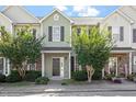 Inviting townhouse with light green siding, well-manicured landscaping, and a charming front entrance at 8326 Glenwood Springs Ct, Raleigh, NC 27616