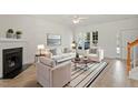 Bright living room with fireplace, large windows, and stylish neutral-toned furniture at 8326 Glenwood Springs Ct, Raleigh, NC 27616