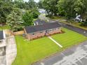 An aerial view captures a brick single-story home with a well-maintained lawn at 1015 S 1St St, Smithfield, NC 27577