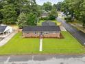 An aerial view captures a brick single-story home with a well-maintained lawn at 1015 S 1St St, Smithfield, NC 27577