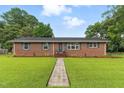 Charming single-story brick home featuring a lush green lawn and a welcoming entryway at 1015 S 1St St, Smithfield, NC 27577