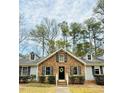 Beautiful one-story brick home featuring manicured bushes, a black door and dormer windows at 103 Cimmaron Ct, Cary, NC 27511