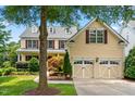 Lovely two-story home with a three car garage, dormer windows, beautiful landscaping, and lush green lawn at 11124 Penderwood Ct, Raleigh, NC 27617